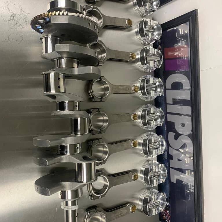 Stroker crankshaft, forged rods and pistons laid out before assembly of a 416ci LS stroker